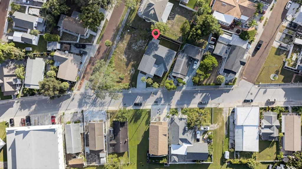 This aerial view shows a residential neighborhood with houses, driveways, and surrounding trees — 207 ATHENS STREET, TARPON SPRINGS, FL