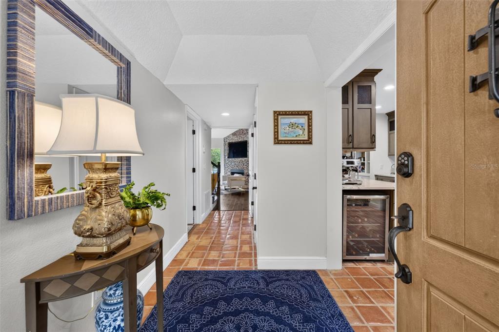 An entryway features a terracotta tiled floor, a blue rug, and a console table — 2881 TEMPLE TRAIL, WINTER PARK, FL