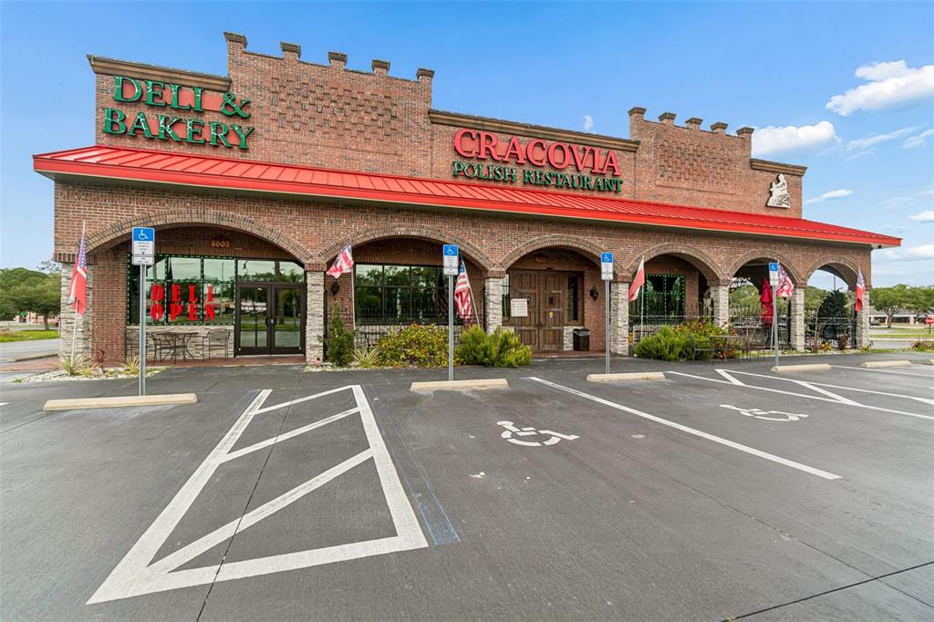 The exterior of a brick building features a red metal roof and arched entryways — 3007 COMMERCIAL WAY, SPRING HILL, FL
