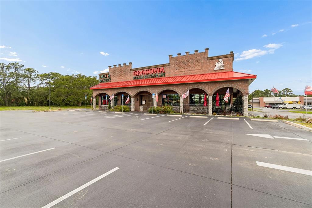 A brick building with a red metal roof houses a Polish restaurant and deli — 3007 COMMERCIAL WAY, SPRING HILL, FL