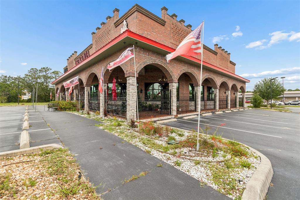 A brick restaurant building features arched covered walkways and a parking lot — 3007 COMMERCIAL WAY, SPRING HILL, FL