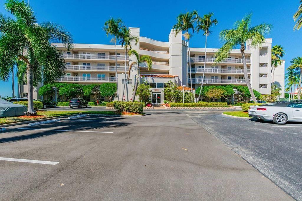 A multi-story apartment building with palm trees and a parking lot in the foreground — 5901 BAHIA DEL MAR CIRCLE UNIT 223, ST PETERSBURG, FL