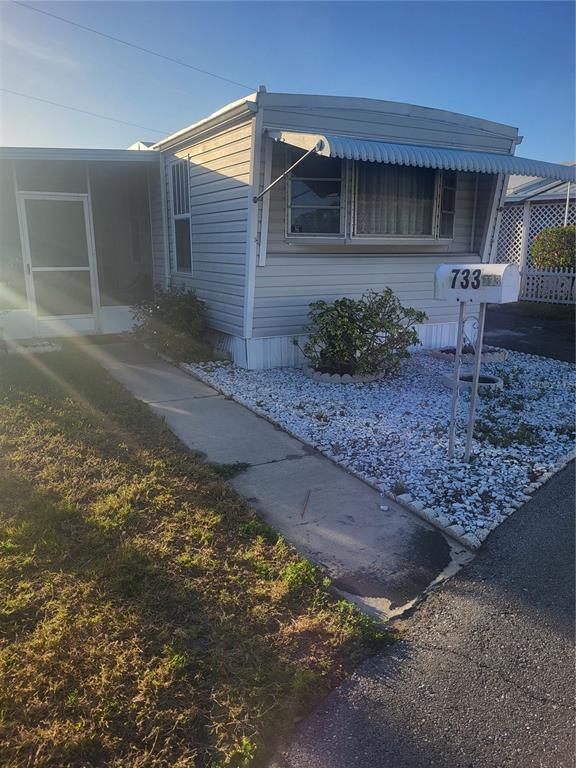 A single-story mobile home features light-colored siding, a metal awning, and a white mailbox — 6580 SEMINOLE BOULEVARD UNIT 733, SEMINOLE, FL