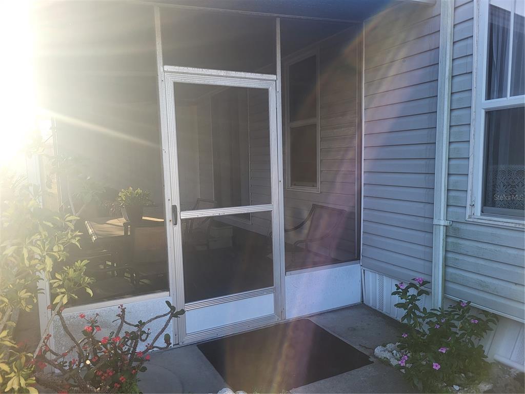 A screened-in porch with a metal door and a concrete patio entrance — 6580 SEMINOLE BOULEVARD UNIT 733, SEMINOLE, FL