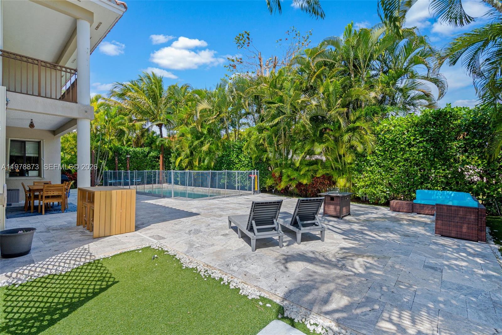 A backyard patio features a swimming pool, lounge chairs, and a dining area under palms — 7515 SW 191st St, Cutler Bay FL 33157, CUTLER BAY, FL