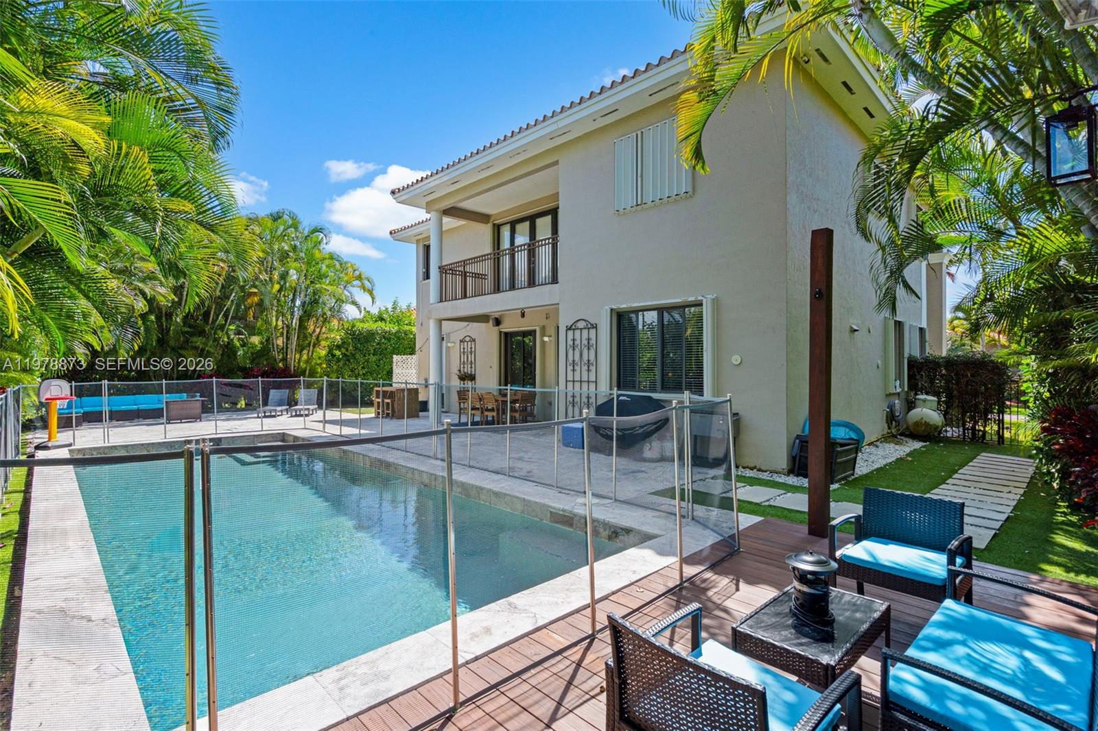 A two-story house features a swimming pool with a safety fence and a wooden deck — 7515 SW 191st St, Cutler Bay FL 33157, CUTLER BAY, FL