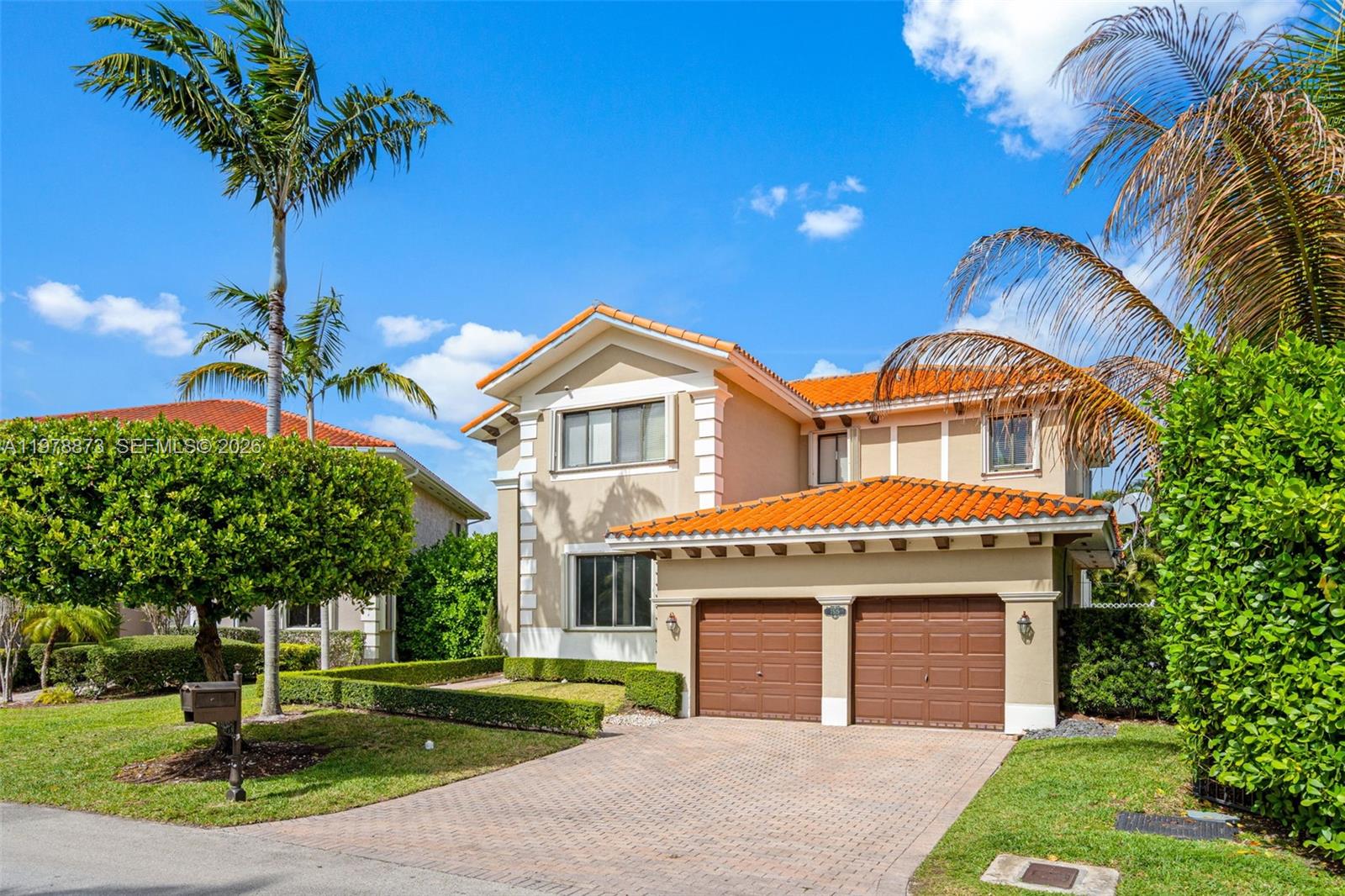 A two-story house with a two-car garage, tan stucco walls, and a red tile roof — 7515 SW 191st St, Cutler Bay FL 33157, CUTLER BAY, FL