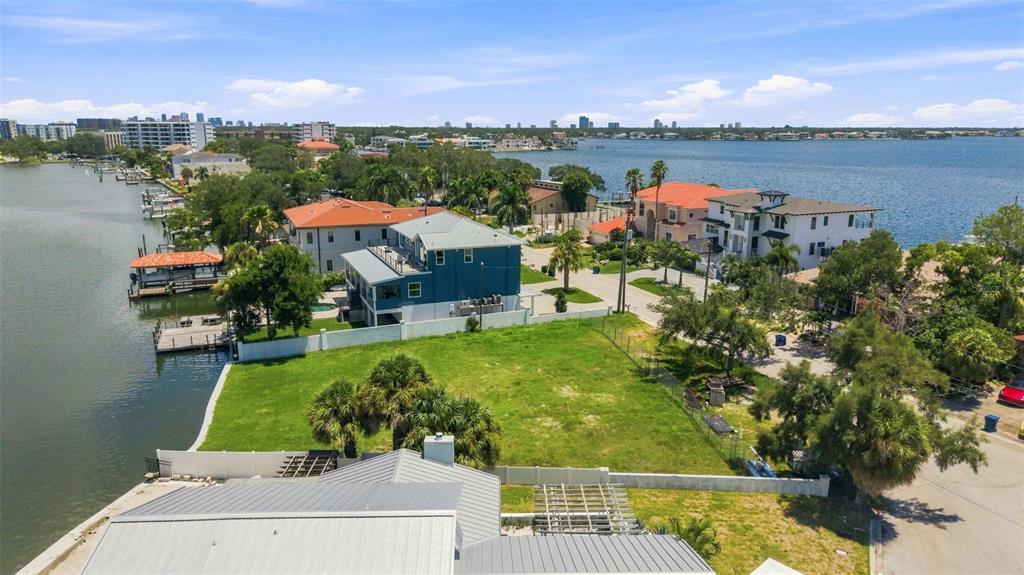 An aerial view shows a vacant waterfront lot situated between two large residential homes — 5833 MARINER STREET, TAMPA, FL