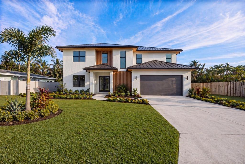 A two-story modern house with a white stucco exterior, dark metal roof, and attached garage — 1235 CORDOVA BOULEVARD NE, ST PETERSBURG, FL