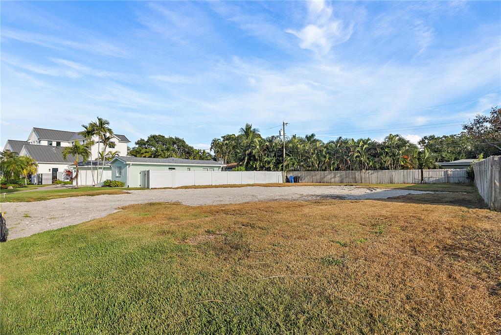 A vacant, grassy lot with a gravel driveway and a white vinyl fence — 1235 CORDOVA BOULEVARD NE, ST PETERSBURG, FL