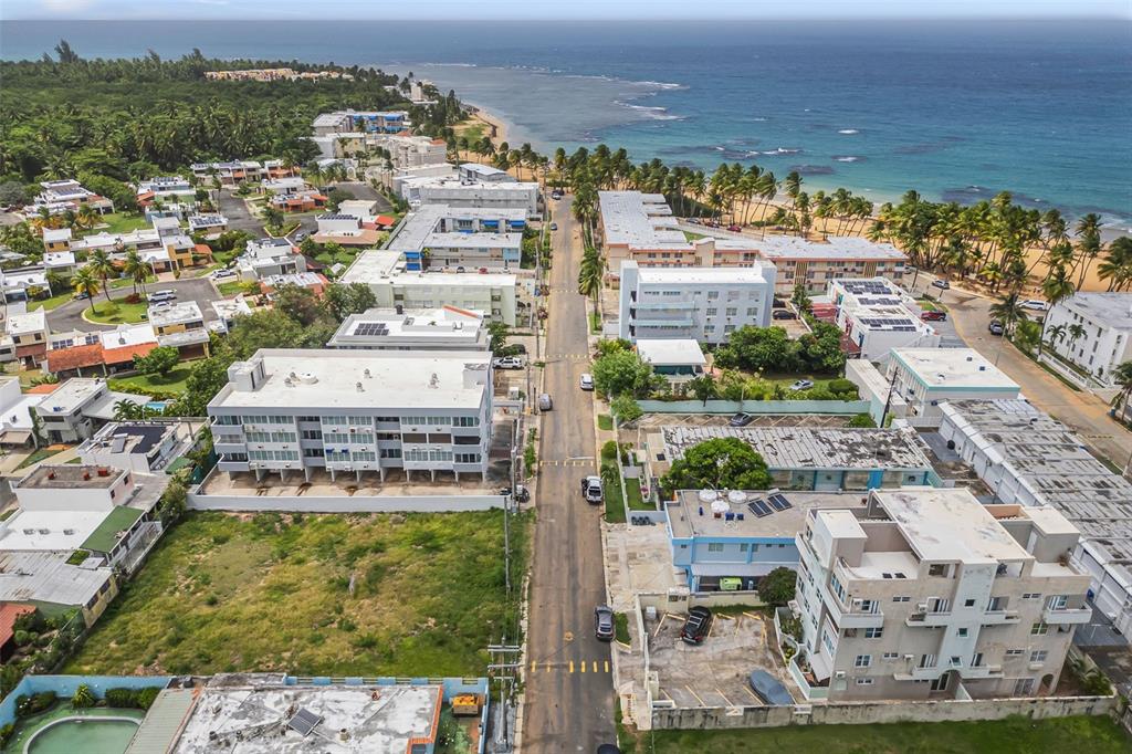An aerial view shows a coastal neighborhood with apartment buildings, a street, and a beach — Cond. Montemar 101, OCEAN DRIVE UNIT 101, LUQUILLO, PR