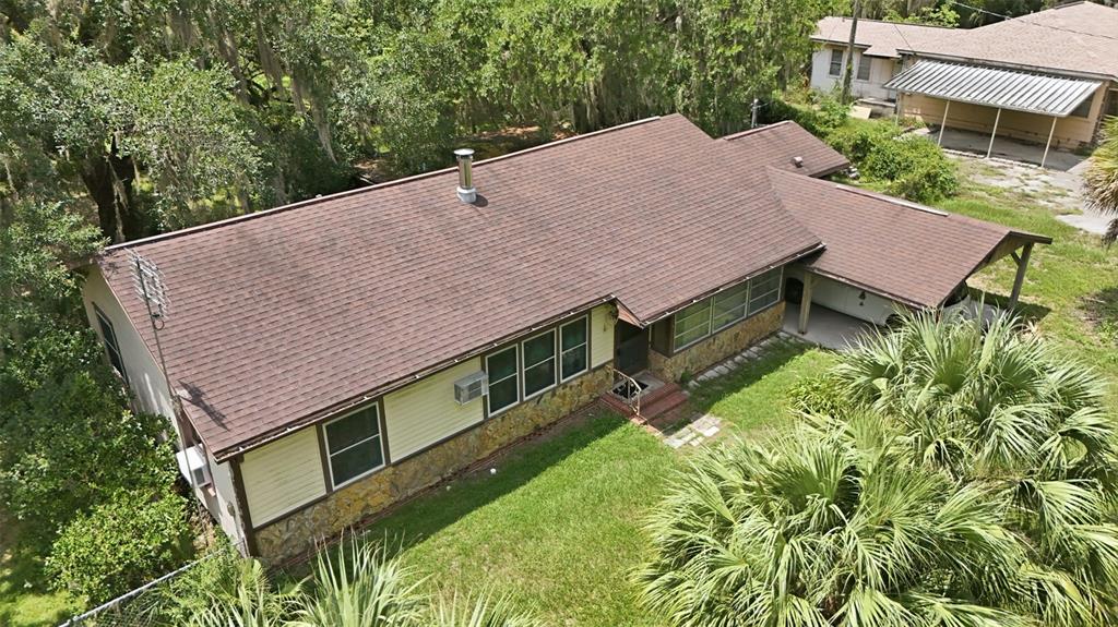 An aerial view of a single-story house with a brown shingled roof and carport — 2104 SE LAKE WEIR AVENUE, OCALA, FL