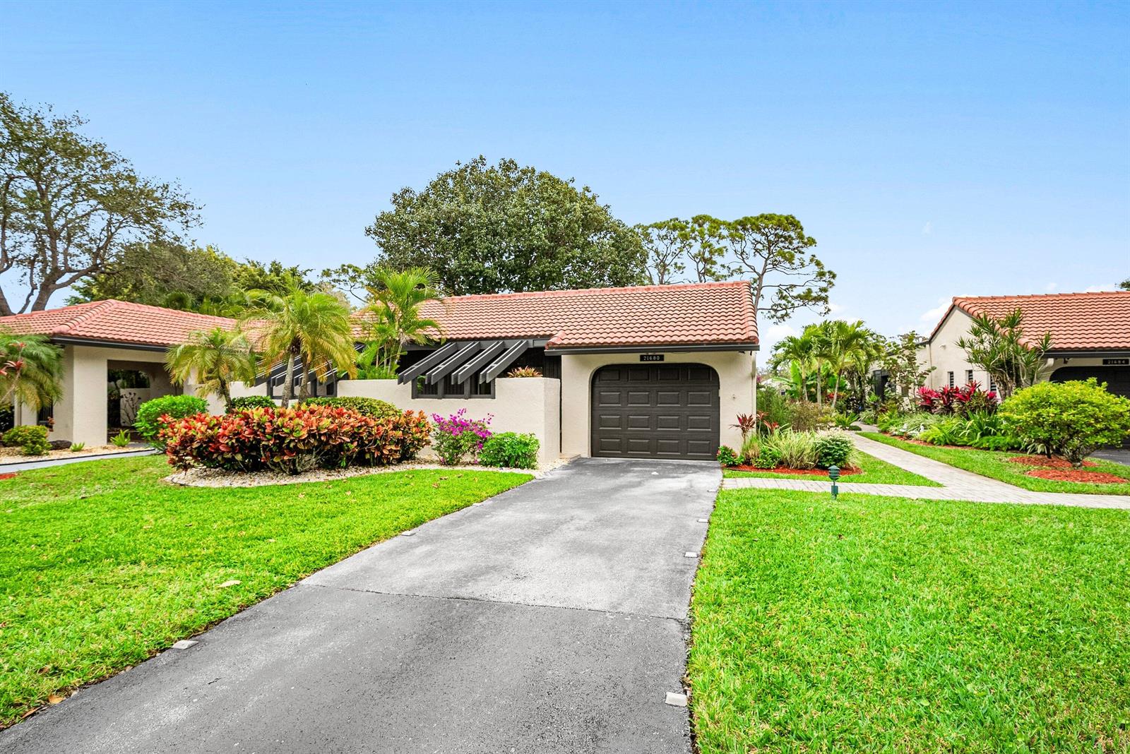 A single-story house with a tile roof, a dark garage door, and a paved driveway — 21680 Tall Palm Circle # B, Boca Raton FL 33433, BOCA RATON, FL
