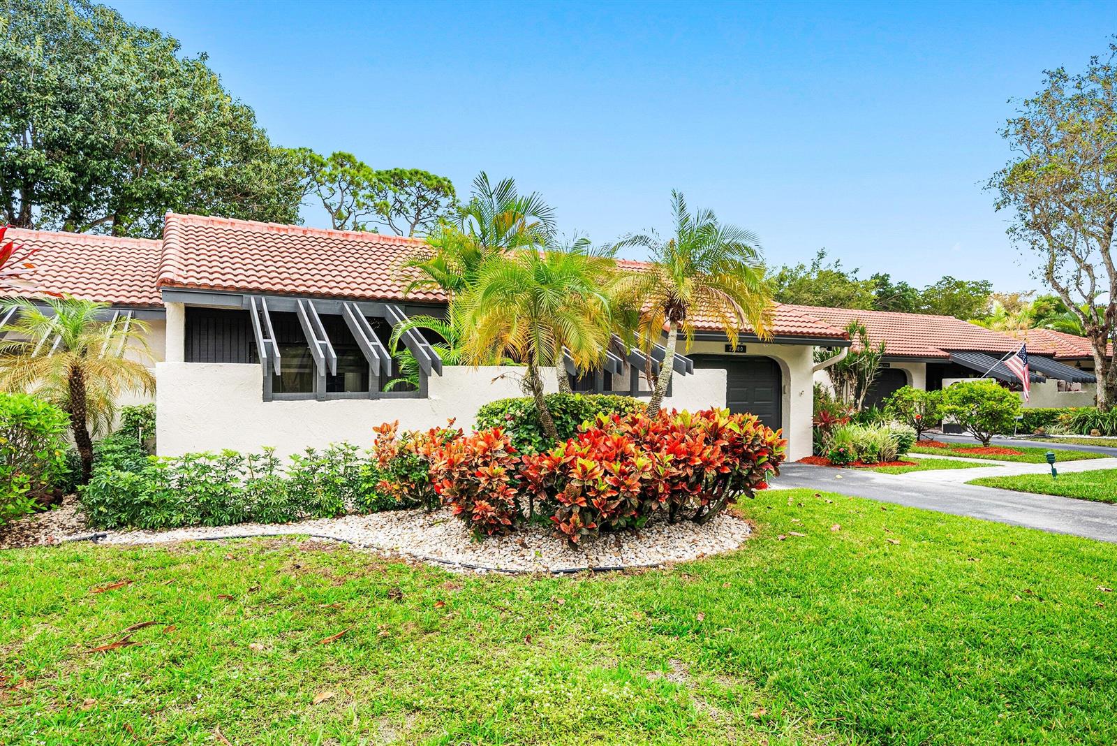 A single-story house with a tiled roof, palm trees, and landscaping in the front yard — 21680 Tall Palm Circle # B, Boca Raton FL 33433, BOCA RATON, FL
