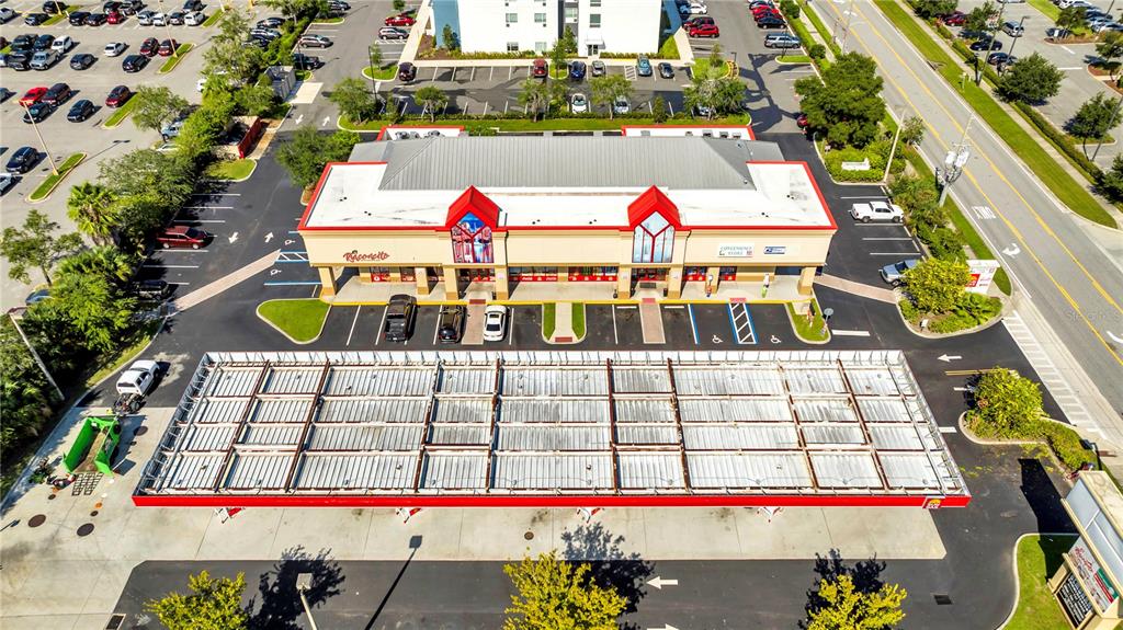 An aerial view shows a commercial building with a large gas station canopy and parking — 5600 BUTLER NATIONAL DRIVE, ORLANDO, FL