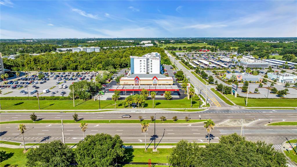 An aerial view shows a hotel with a gas station and parking lots nearby — 5600 BUTLER NATIONAL DRIVE, ORLANDO, FL