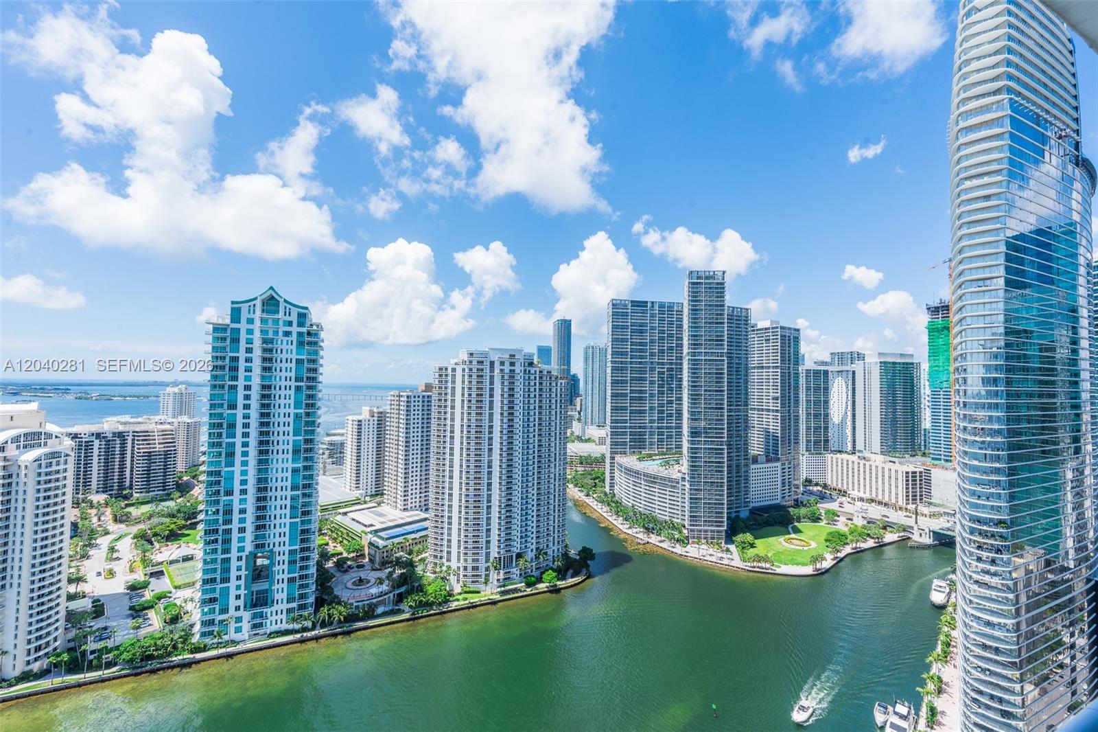 An elevated view of a city skyline featuring multiple high-rise buildings along a river — 325 S Biscayne Blvd # 3821, Miami FL 33131, MIAMI, FL