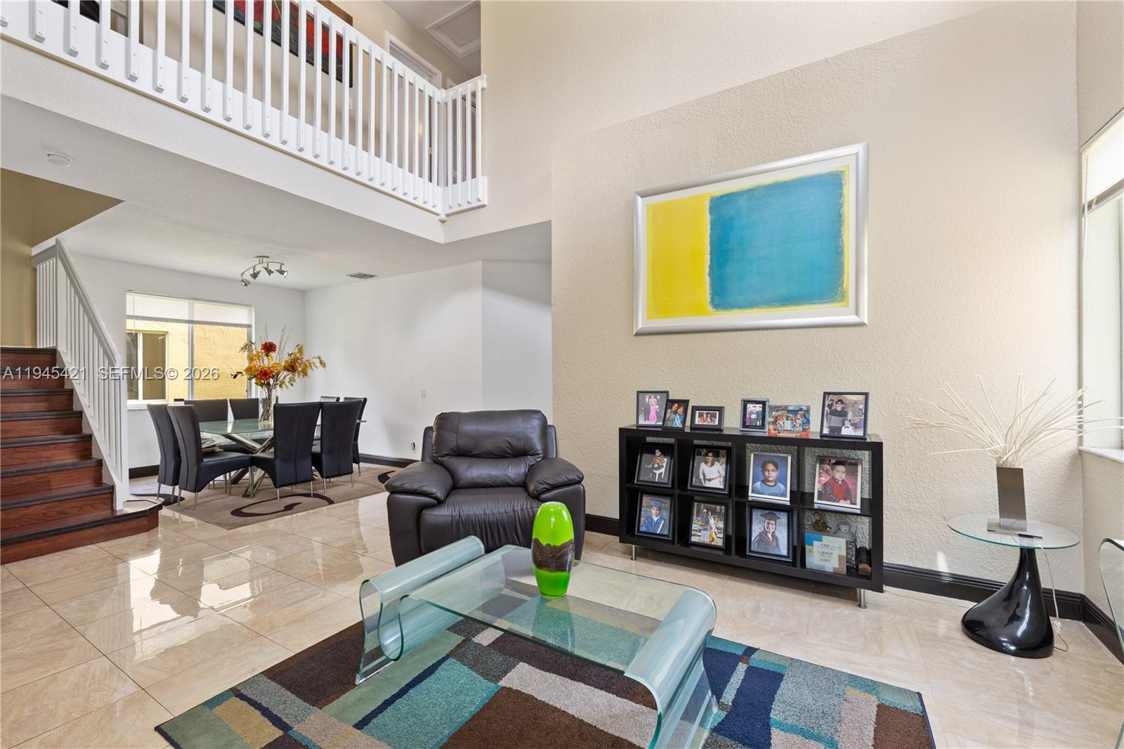A living room with tile floors, a glass coffee table, and a staircase — 1199 Golden Cane Dr, Weston FL 33327, WESTON, FL