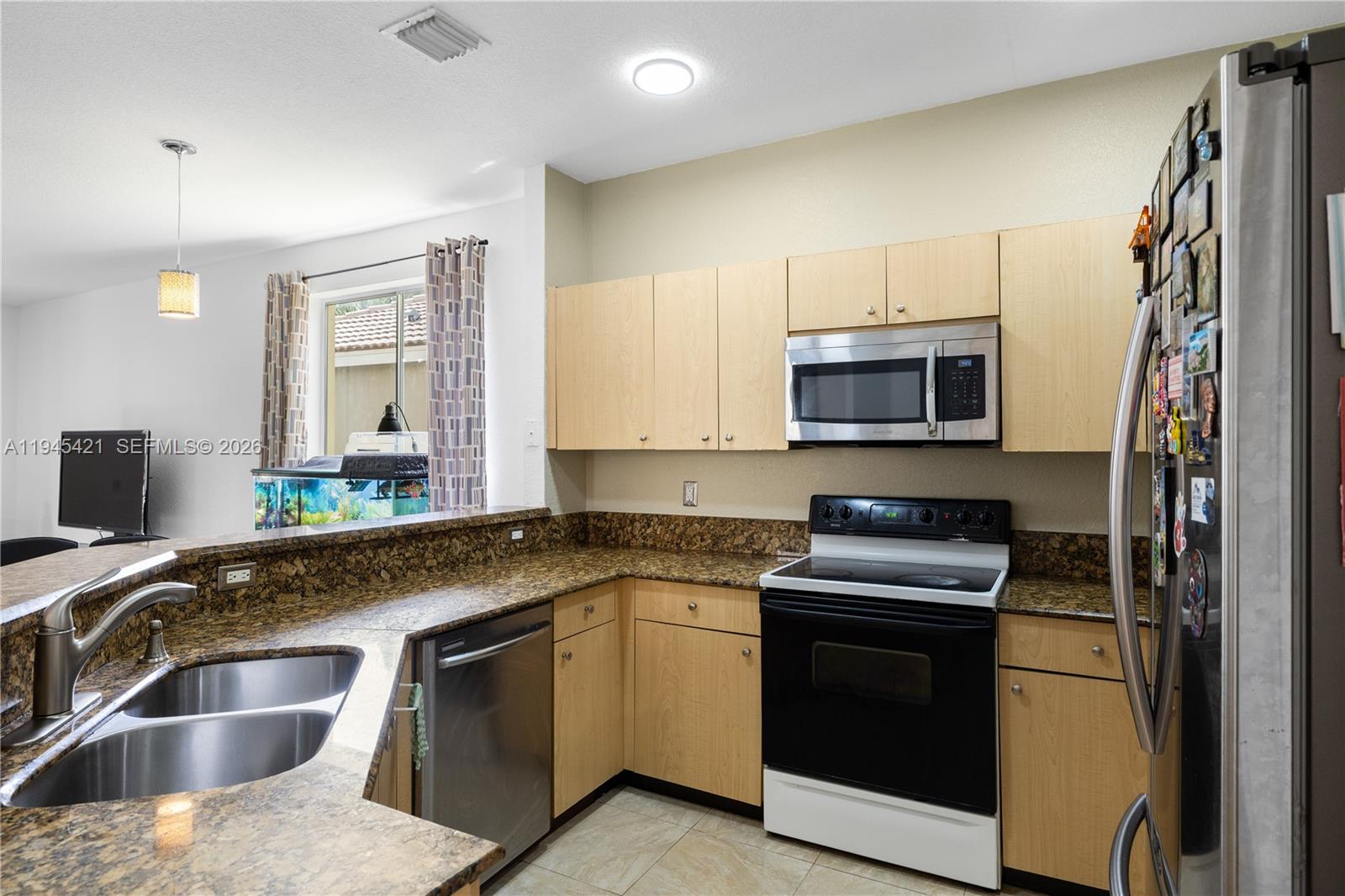 A kitchen features light wood cabinets, granite countertops, stainless steel appliances, and a double sink — 1199 Golden Cane Dr, Weston FL 33327, WESTON, FL