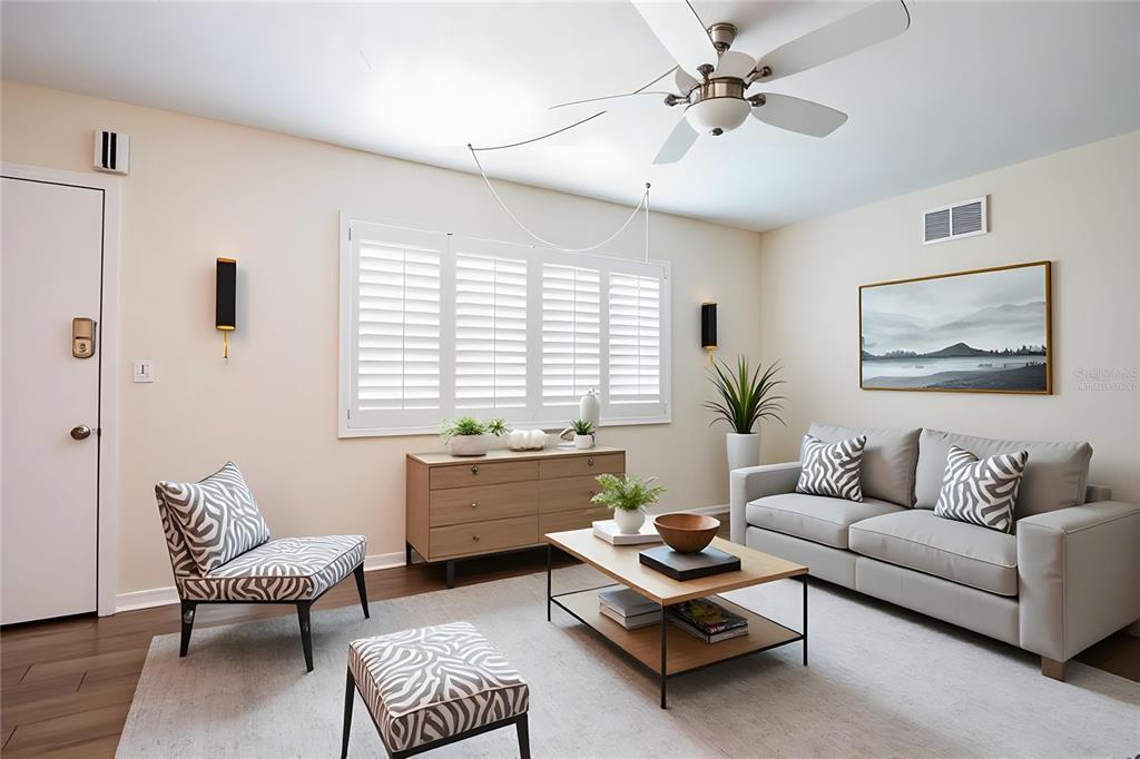 A living room features a grey sofa, zebra-print accent chair, wooden coffee table, and ceiling fan — 5267 81ST STREET N UNIT 21, ST PETERSBURG, FL