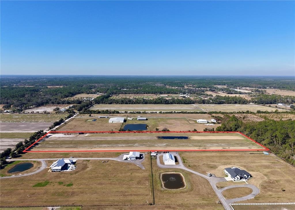 An aerial view shows a large, rectangular plot of land outlined in red — 3761 STRAWBERRY LANE, NEW SMYRNA BEACH, FL