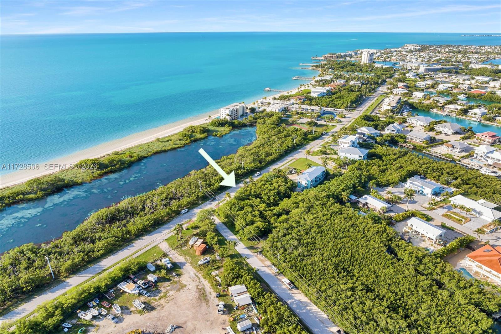 An aerial view shows a coastal road running alongside a body of water and vegetation — 300 Coco Plum, Marathon FL 33050, MARATHON, FL