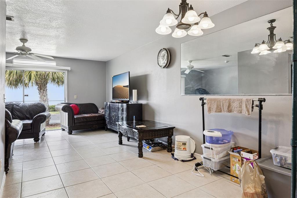 A living room with tile floors, a ceiling fan, a television, and a large wall mirror — 2460 SUMMERFIELD WAY, KISSIMMEE, FL
