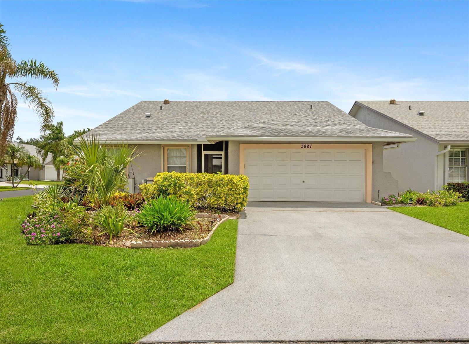 A single-story house with a gray shingled roof, a two-car garage, and landscaped front yard — 3897 Dafilee Circle, West Palm Beach FL 33417, WEST PALM BEACH, FL