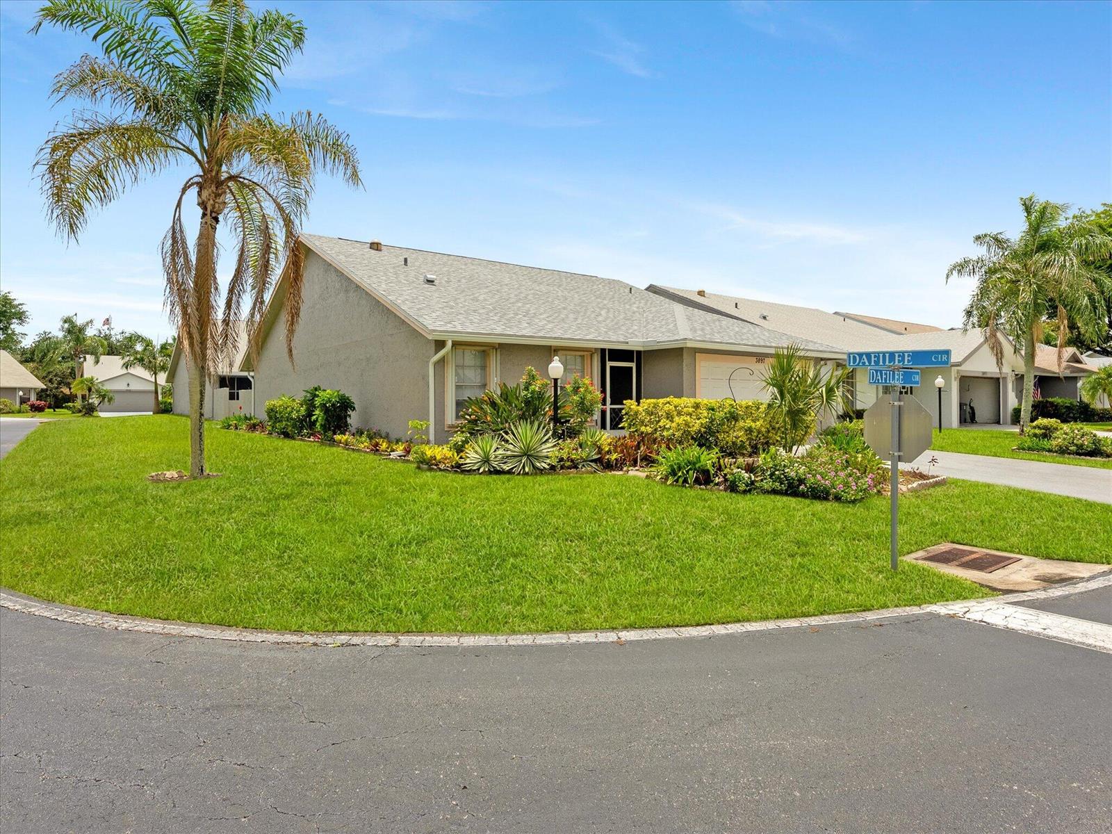 A single-story house with a gray exterior, a palm tree, and landscaping on a corner lot — 3897 Dafilee Circle, West Palm Beach FL 33417, WEST PALM BEACH, FL