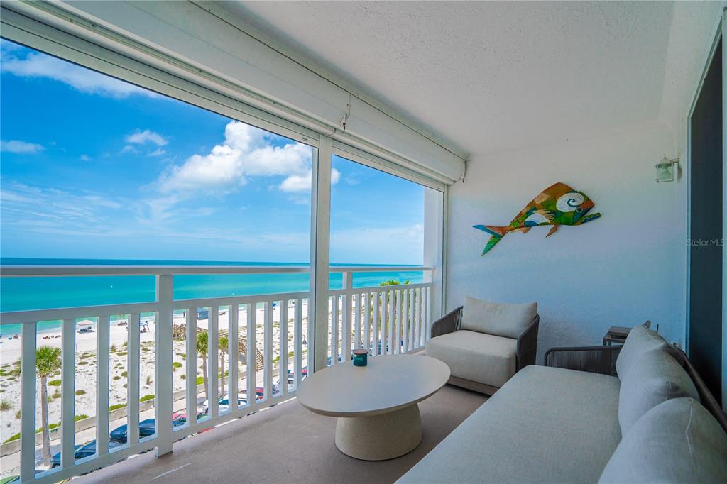 A balcony with outdoor seating overlooks a sandy beach and the ocean — 555 GULF WAY UNIT 6S, ST PETE BEACH, FL