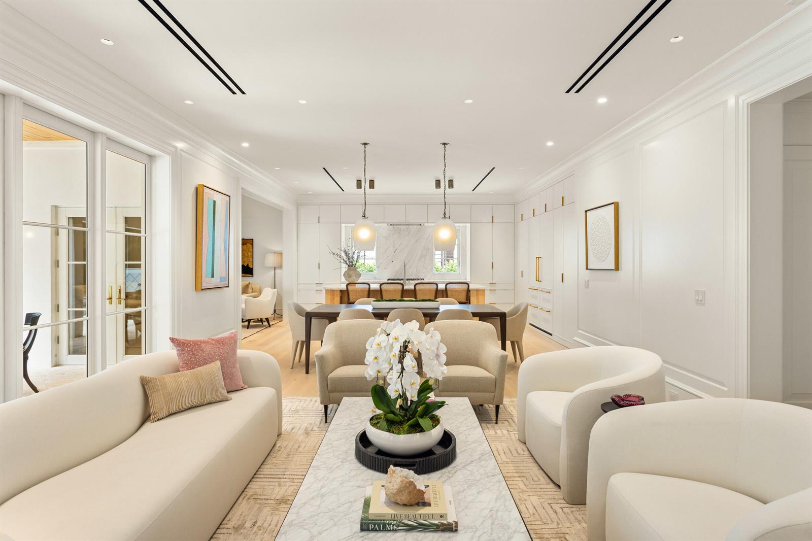 A bright, open-concept living and dining area features white walls, marble accents, and neutral furniture — 224 Southland Road, Palm Beach FL 33480, PALM BEACH, FL