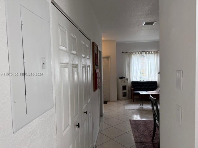 A hallway with a white electrical panel and closet doors leads to a living area — 5737 NW 114th Path # 113, Doral FL 33178, DORAL, FL