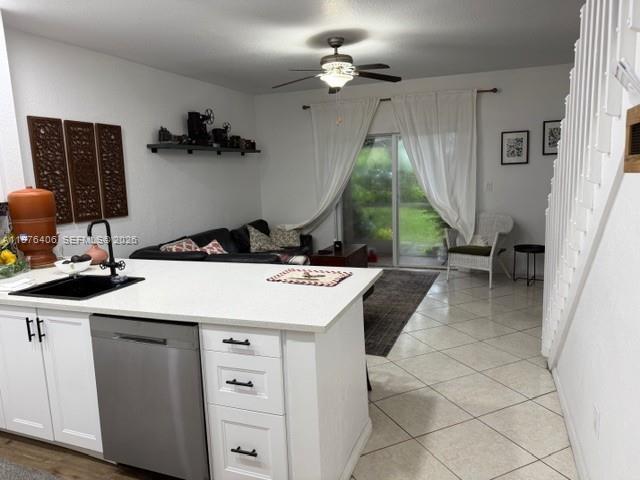 A kitchen island with a stainless steel dishwasher faces a living area with sliding doors — 5737 NW 114th Path # 113, Doral FL 33178, DORAL, FL