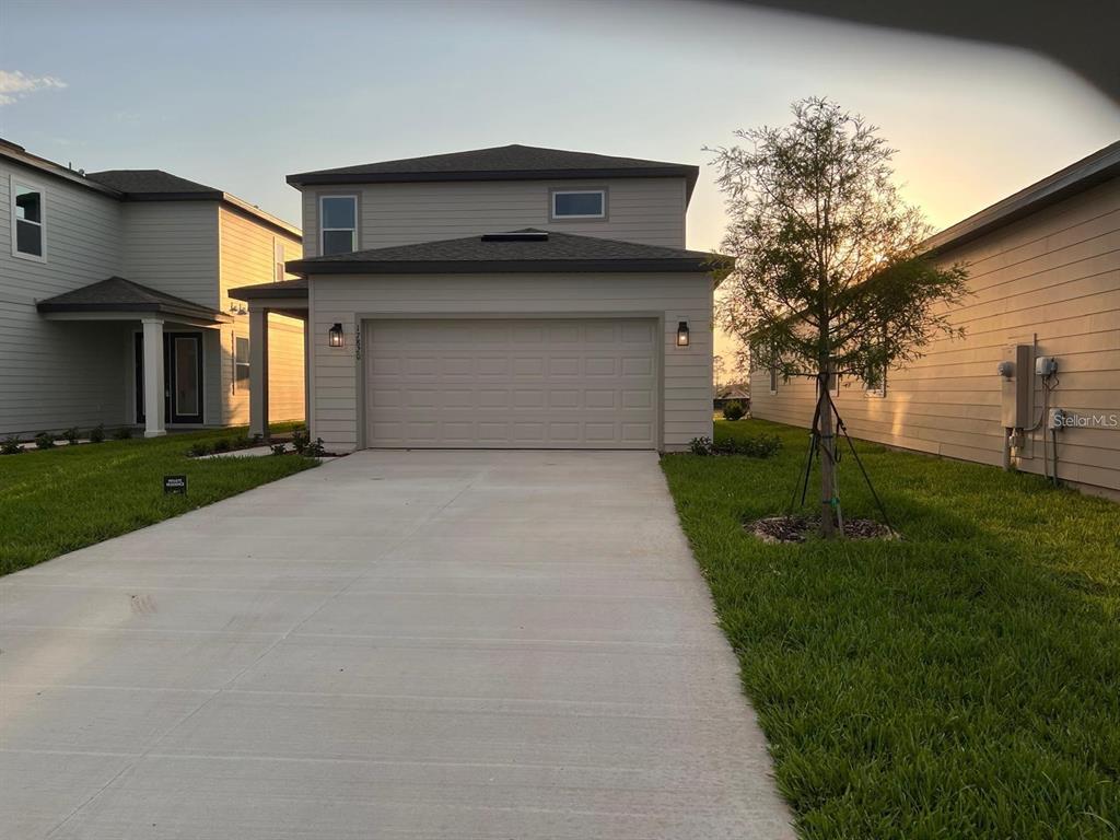 A two-story house with light siding, a two-car garage, and a concrete driveway — 17820 SHARP PUMMELO ALLEY, WINTER GARDEN, FL