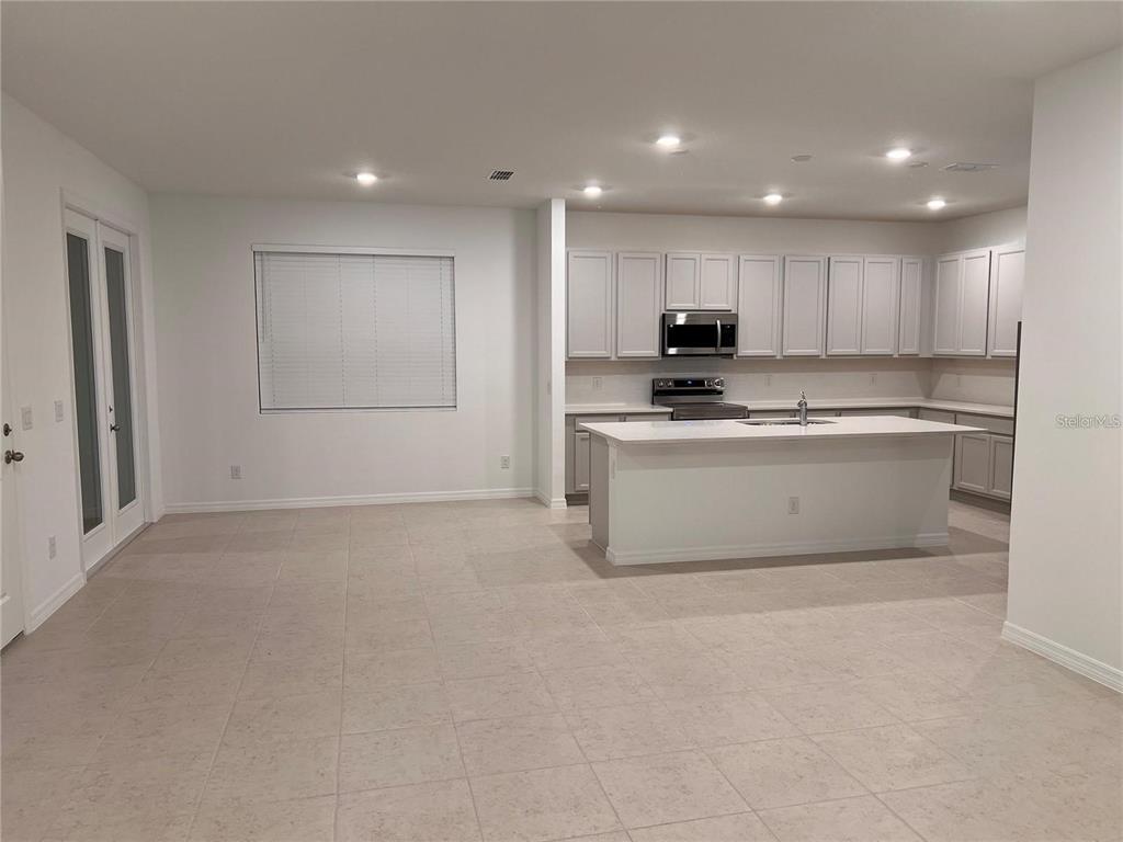 A kitchen with light gray cabinets, a central island, and tile flooring — 17820 SHARP PUMMELO ALLEY, WINTER GARDEN, FL