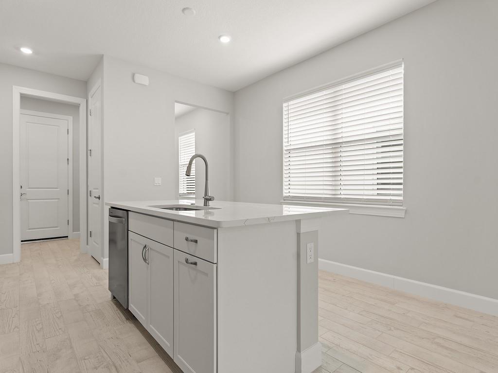 A kitchen island with a stainless steel sink and dishwasher sits in a light-filled room — 4501 Nautilus Circle, Vero Beach FL 32967, VERO BEACH, FL