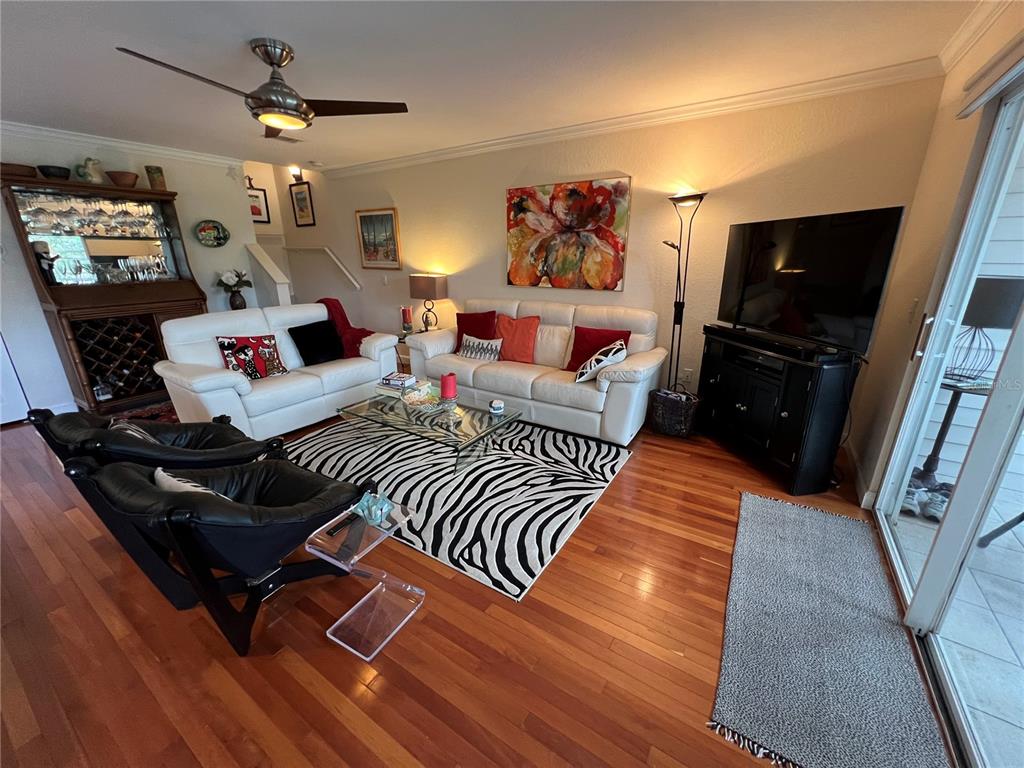 A living room features white sofas, a zebra-print rug, hardwood floors, and a television console — 850 S TAMIAMI TRAIL UNIT 333, SARASOTA, FL