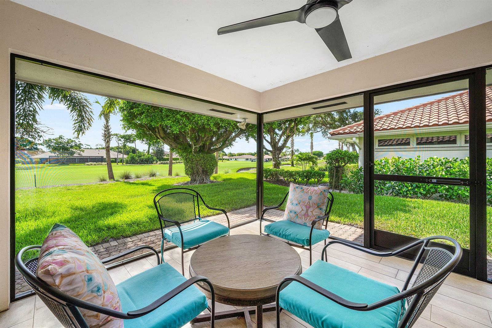 A screened-in patio features a round table, four chairs, and views of a golf course — 10420 Seaholly Terrace, Boynton Beach FL 33436, BOYNTON BEACH, FL
