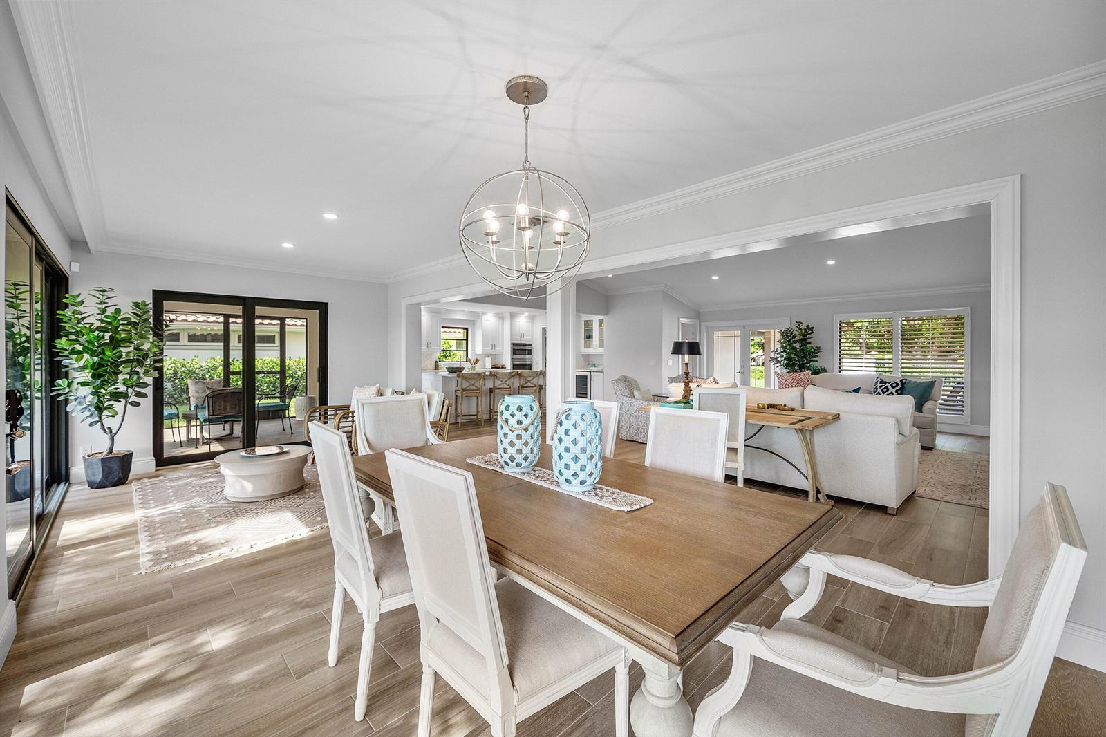A dining room with a wooden table and chairs opens into a living area and kitchen — 10420 Seaholly Terrace, Boynton Beach FL 33436, BOYNTON BEACH, FL