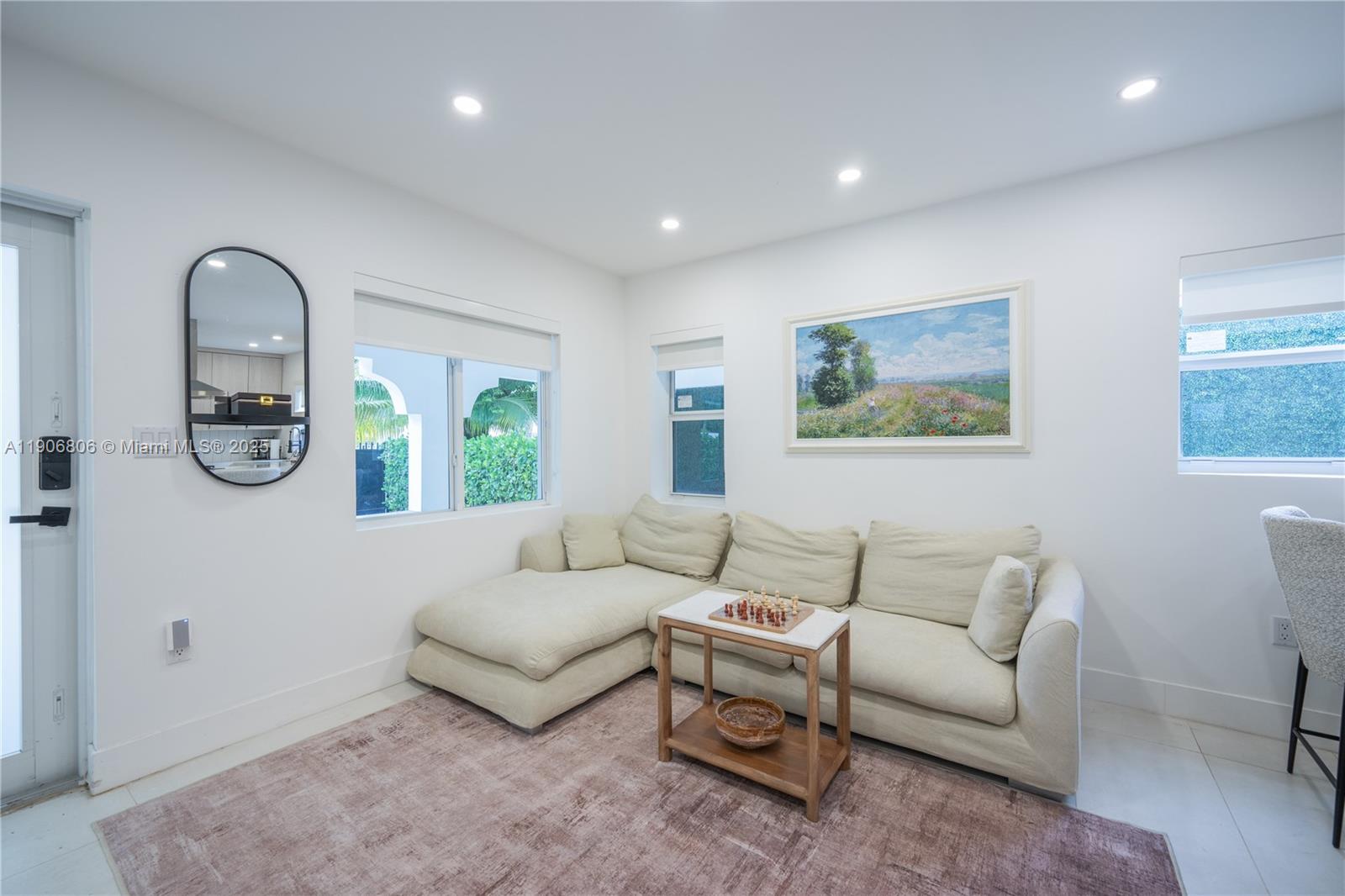A living room features a beige sectional sofa, a small wooden table, and a rug — 545 NW 47th St, Miami FL 33127, MIAMI, FL