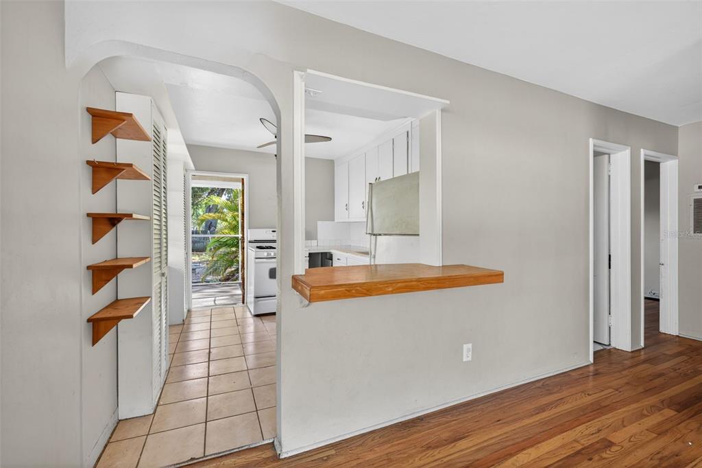 A view from a living area into a kitchen with a breakfast bar and shelves — 2122 6TH AVENUE N, ST PETERSBURG, FL