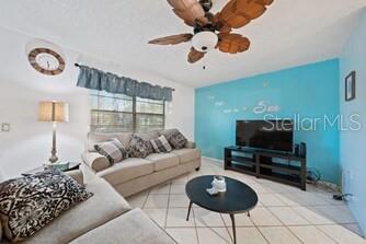 A living room features a beige sofa, a coffee table, and a blue accent wall — 344 50TH STREET W, PALMETTO, FL