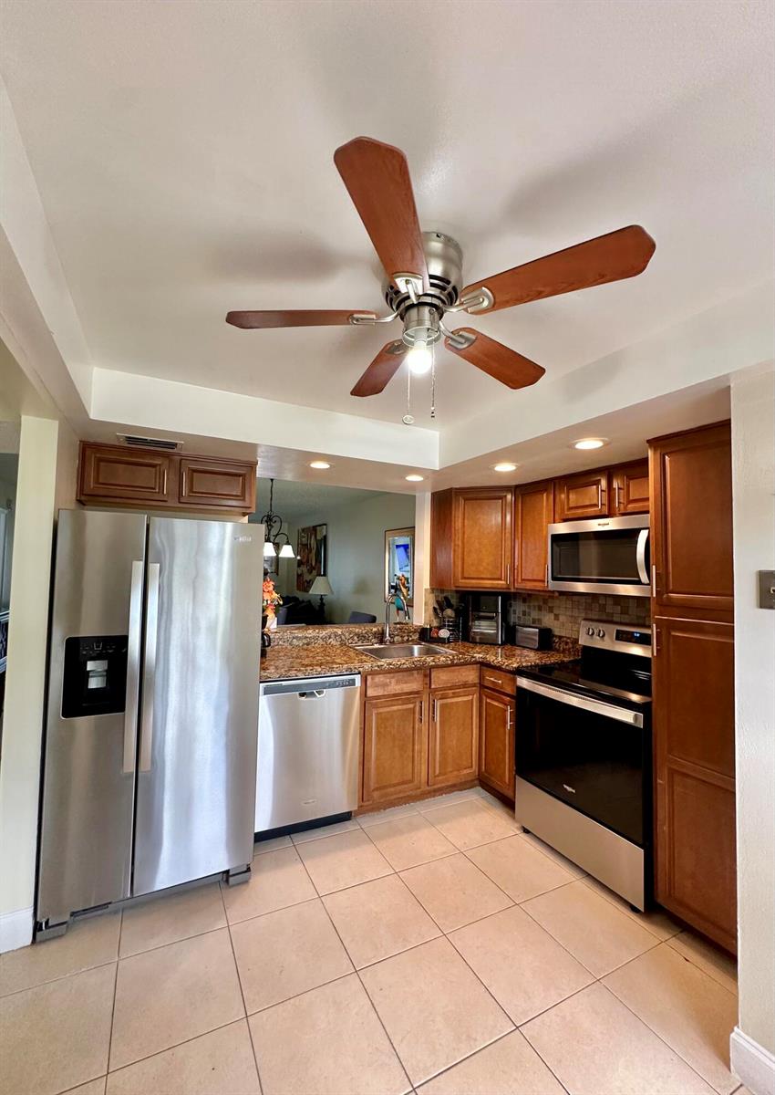 A kitchen features stainless steel appliances, wood cabinets, granite countertops, and a ceiling fan — 1650 NW 80th Avenue, Margate FL 33063, MARGATE, FL