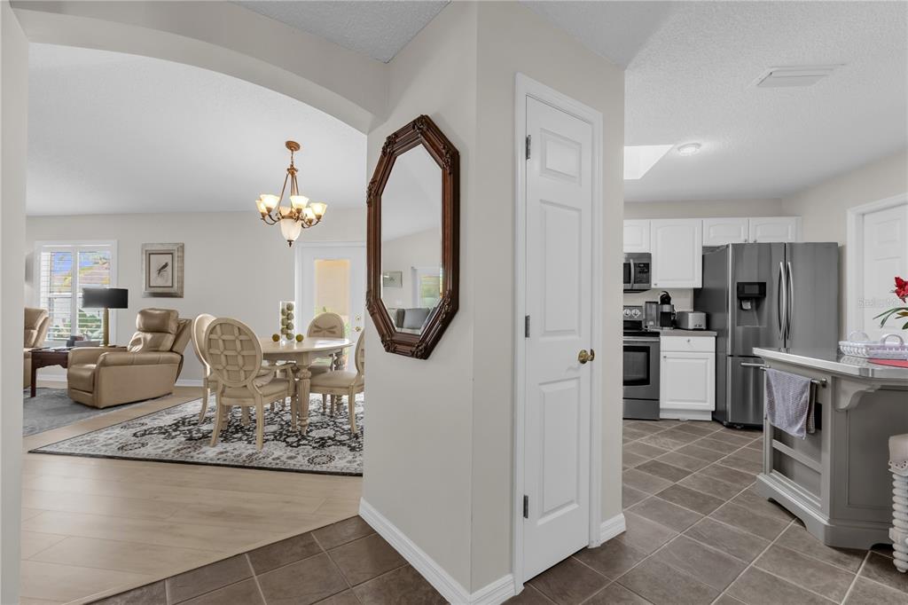 A view from a tiled entryway looking into a dining area and a modern kitchen — 1214 SAN BERNARDO ROAD, THE VILLAGES, FL