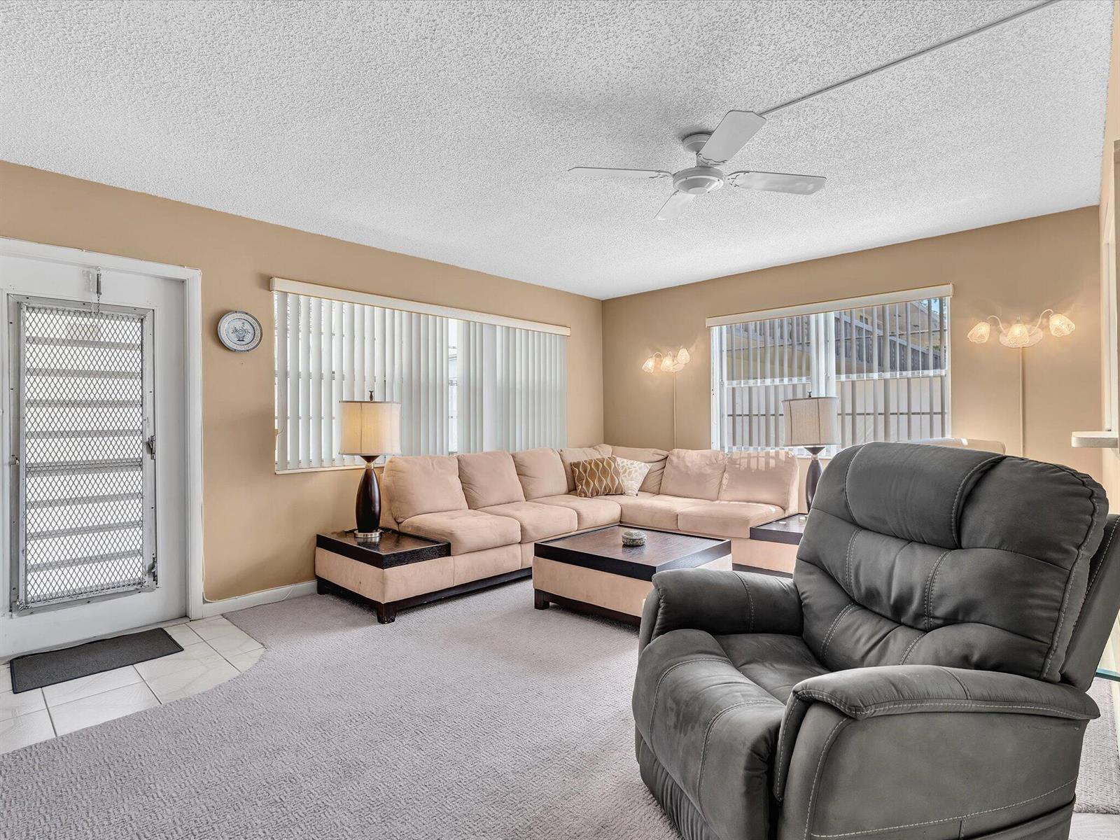 A living room features a beige sectional sofa, a grey recliner, and a ceiling fan — 5 Markham A, Deerfield Beach FL 33442, DEERFIELD BEACH, FL