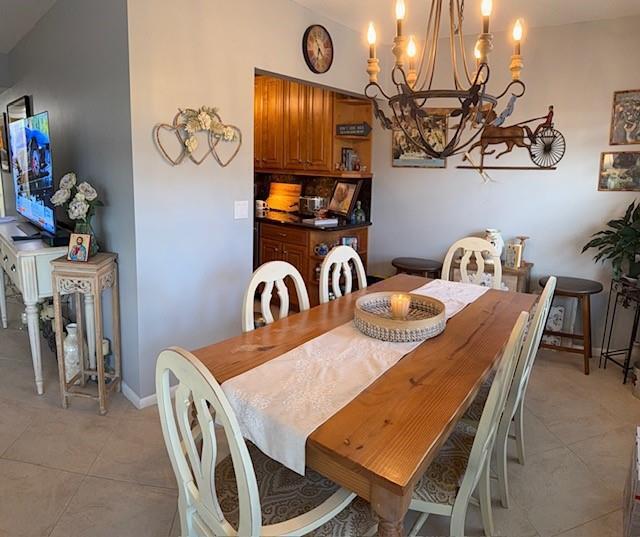 A dining room features a wooden table, white chairs, and a chandelier under a clock — 284 Grantham F, Deerfield Beach FL 33442, DEERFIELD BEACH, FL