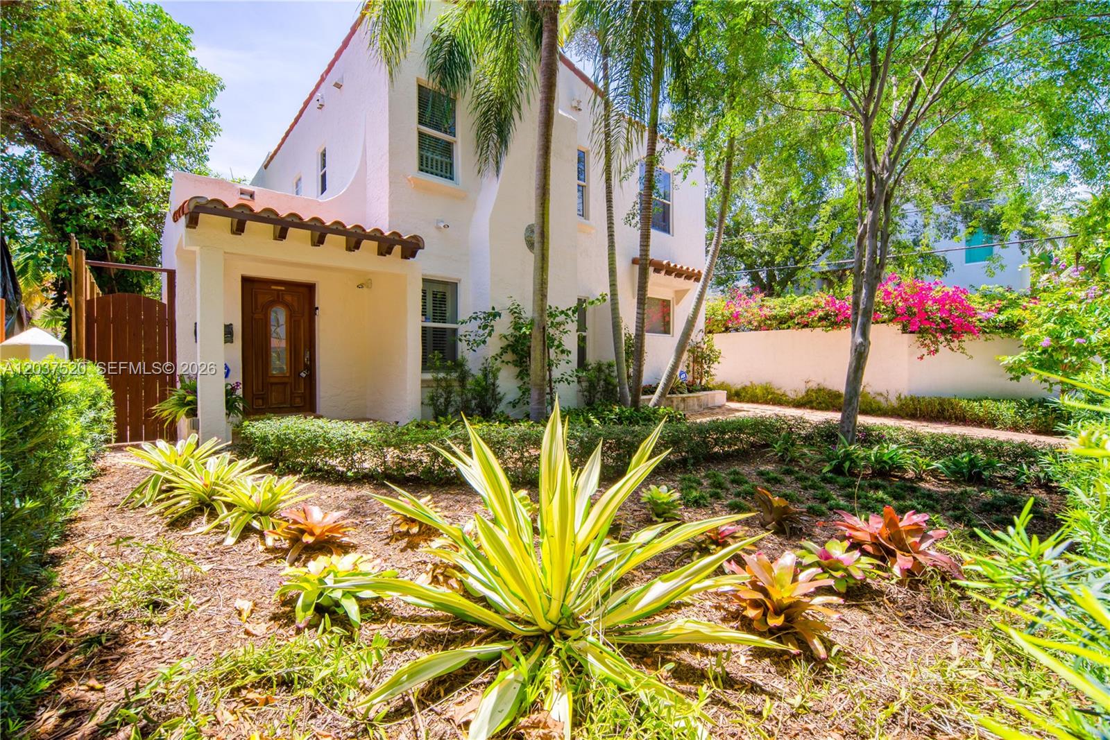 A two-story stucco house with a wooden front door and tropical landscaping — 3514 Crystal Ct, Miami FL 33133, MIAMI, FL