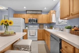 A dining room features a wooden table, white chairs, a light fixture, and a wall clock — 3324 CANDLEBROOK STREET, THE VILLAGES, FL