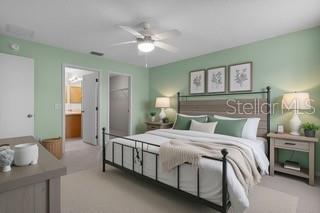 An open-concept living room and kitchen featuring light blue walls, beige furniture, and wood cabinetry — 3324 CANDLEBROOK STREET, THE VILLAGES, FL
