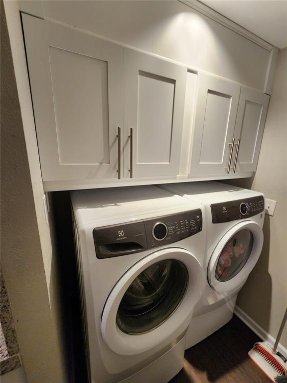A laundry room features white cabinets mounted above a side-by-side Electrolux washer and dryer — 149 SEA ISLE CIRCLE, SOUTH DAYTONA, FL